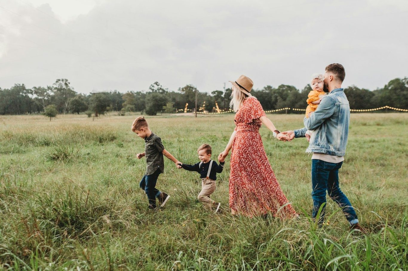 Copyright: Jessica Rockowitz auf Unsplash Familie mit 3 Kindern spaziert über eine Wiese